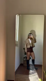 Campera corta de ecocuero color beige, con diseño de solapas y cierre frontal con botones a presión metálicos.