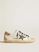 Zapatillas Golden Goose modelo Super-Star en color blanco, con acabado desgastado, la emblemática estrella lateral y detalle en el talón con brillo dorado, además de cordones estampados.