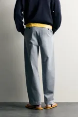 Pantalón chino para hombre de corte relajado, confeccionado en tejido de algodón con efecto lavado en color celeste. Cuenta con bolsillos delanteros, bolsillos traseros de vivo con botón y cierre frontal con cremallera y botón.