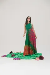 Vestido largo de microtul elastizado y lycra color verde con estampado de plumerillo en tonos rosa, amarillo y naranja. Tiene cuello americano y corte acampanado.