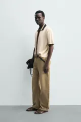 Camisa de punto de algodón con corte relajado, cuello solapa y manga corta. Presenta un diseño bicolor en tonos beige y marrón, con cierre frontal de botones.