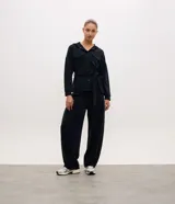 Campera utilitaria deportiva marrón de poliamida, con capucha, cierre frontal de botones, bolsillos con solapa en el pecho y lazo ajustable en la cintura.