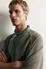 Camiseta relaxed fit de color verde militar, con cuello redondo y mangas ranglán cortas.