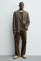Bota estilo Chelsea de hombre, confeccionada en piel con acabado de serraje en color beige. Presenta elásticos laterales al tono, horma redonda y suela de goma a contraste con ligero tacón.