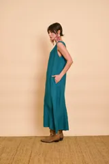 Vestido largo color verde petróleo con escote en V, detalles de bordado metálico en el escote y bolsillos laterales.