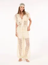 Pantalón balloon de mujer color beige, confeccionado con aplicaciones de encaje y detalles calados que aportan textura y un acabado artesanal. Presenta una silueta voluminosa y corte amplio en las piernas.