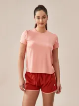 Remera deportiva de manga corta en color salmón, con cuello redondo y costuras laterales reforzadas.
