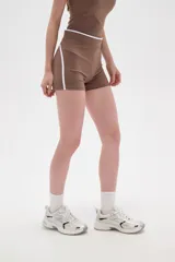 Short tipo biker de poliamida, color marrón camel, con diseño ajustado al cuerpo, cintura alta y detalle de línea lateral blanca.