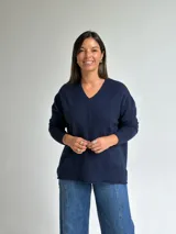 Sweater de punto en color azul marino, con escote en V, manga larga con puños acanalados y costura central vertical en el frente.