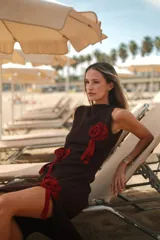 Vestido midi de lurex marrón con brillo sutil, cuello a la base, sin mangas, con apliques de flores en relieve y tajo lateral en la falda.