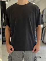 Remera oversize de manga corta en color negro con efecto gastado (acid wash) y cuello redondo.