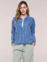 Camperita de denim liviano color azul, con cuello camisero, botones frontales ocultos, mangas largas de hombros caídos, bolsillos laterales y cordón ajustable en la cintura.