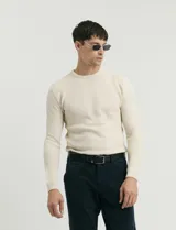 Sweater de punto con textura tipo waffle, color negro, de corte clásico con cuello redondo y mangas largas.