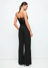 Pantalón de vestir negro de corte recto y tiro medio, con bolsillos laterales y diseño amplio.
