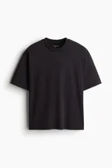Remera deportiva negra de corte boxy, confeccionada en tejido funcional DryMove™ con efecto lavado. Tiene cuello redondo ribeteado acanalado y hombros caídos.