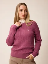 Sweater de punto con diseño de trenzas verticales, color negro, con cuello redondo, mangas largas y puños con detalle en contraste blanco. Presenta un pequeño logo bordado en el pecho.