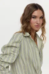 Camisa de lino y viscosa con diseño a rayas verdes y azules, cuello camisero, manga larga raglán con fruncidos y corte cruzado en el frente.