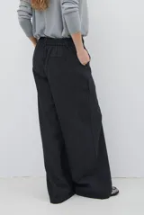 Pantalon de corte sastrero y pierna ancha, confeccionado en tela melange. Presenta cintura con trabillas, cierre frontal con botón y bolsillos laterales.