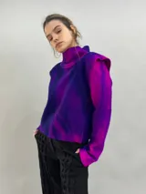Buzo de lana merino afieltrada con diseño artesanal de efecto degradado en tonos violeta y fucsia. Presenta cuello alto, hombreras marcadas y corte holgado.