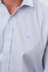 Camisa de vestir de manga larga con diseño a rayas finas en color celeste y blanco, cuello camisero tradicional, cierre frontal con botones y bordado pequeño en el pecho.