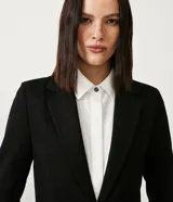 Blazer alargado color gris oscuro, con cuello solapa, bolsillos incorporados y cierre frontal con dos botones.