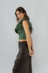 Top corto marrón con brillos, de un solo hombro y volados grandes en el escote.