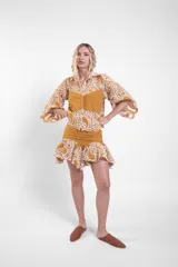 Camisa corta de encaje de algodón con diseño geométrico y detalles de tela lisa en tono mostaza, cuello camisero y mangas amplias con volados.