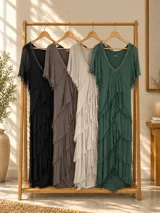 Vestido largo de seda italiana color verde oscuro, con capas escalonadas con flecos, escote en V con detalle de paillettes y mangas cortas fluidas.
