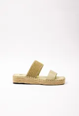 Sandalias bajas color verde claro, con doble tira en el empeine de diferentes texturas: una de cuero sintético liso y otra trenzada. Plataforma de yute de 3.5 cm de alto.