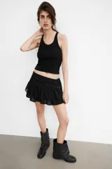 Top de punto con cuello halter y escote redondo, sin mangas y diseño ajustado.