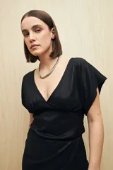 Top negro de tejido acanalado con acabado brillante, escote en V profundo, manga corta y frunce bajo el busto.