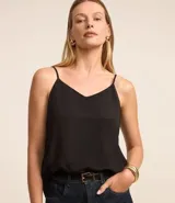 Blusa musculosa de crepé color negro, con escote en V y breteles finos ajustables. Presenta un corte holgado y fluido.