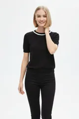 Remera de algodón al cuerpo en color negro, con mangas cortas y cuello redondo adornado con cordón blanco.