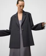 Blazer gris melange de corte holgado con solapa de muesca y cierre frontal de un solo botón. Presenta mangas largas con detalle de organza transparente en los puños y un diseño en la espalda con cruces, drapeados y aberturas. Confeccionado en una mezcla de poliéster y lana merino.