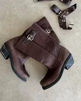 Bota de cuero marrón con caña alta y estribo desmontable.