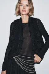 Cinturón plateado con múltiples eslabones y anillas metálicas. Cierre con mosquetón.