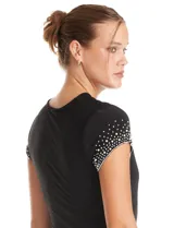 Enterito de seda fría color negro, con escote en V cruzado, mangas cortas decoradas con apliques de brillo y perlas, cintura elástica con lazo lateral ajustable y pierna de corte recto.