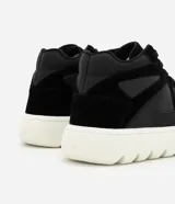 Championes de corte medio confeccionados en poliuretano negro, con diseño de paneles combinados y perforaciones laterales. Presentan cierre con cordones y una suela track alta de color blanco con relieve.