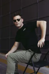 Remera de algodón color verde oliva, con cuello redondo, manga corta y estampado gráfico frontal con texto alusivo a motocicletas.