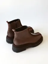 Bota corta de cuero en tonos chocolate, con diseño de paneles texturizados y suela track robusta de goma.