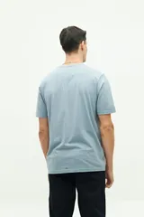 Remera de manga corta color beige con estampado fotográfico en el pecho. Presenta un corte regular y cuello redondo.