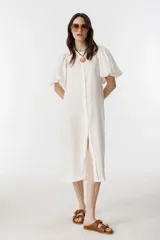 Vestido midi blanco de lino con cuello mao, mangas globo al codo y botones de nácar delanteros.