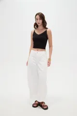 Pantalón de jean blanco de tiro medio, con diseño de silueta barrel, bolsillos clásicos y costuras con pinzas decorativas en la zona de las rodillas.