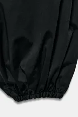 Pantalón negro de tiro medio con cintura ajustable mediante cordones y bajo abullonado con puño elástico.