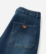 Pantalón de jean modelo flare, de tiro alto, con cierre frontal de botones a la vista y bolsillos funcionales.