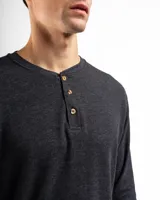 Remera tipo henley de manga larga confeccionada en tejido de algodón con textura mini piqué. Presenta un cierre frontal con tres botones y puños ajustados en las mangas.