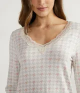 Pijama largo de dos piezas en tejido viscolycra. La blusa es de manga larga con cuello en V y detalles de encaje. El pantalón es liso con cintura elástica y encaje en el ruedo.