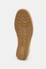 Zapatillas planas de gamuza en color tostado, con diseño minimalista, suela de goma al tono y cordones blancos.