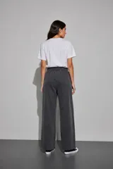 Pantalón de felpa color marrón, de corte ancho y relajado, cintura elástica con cordón ajustable y bolsillos laterales.