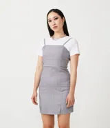 Vestido corto gris con rayas verticales blancas, escote recto, tirantes finos ajustables y aberturas en el ruedo.